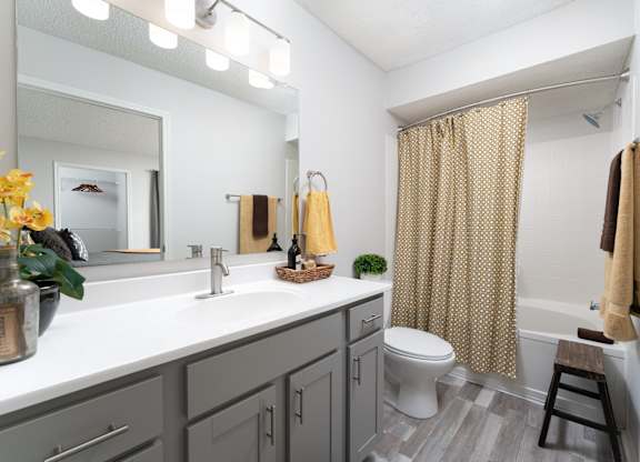 Updated bathroom featuring a modern shower, sink, and toilet
