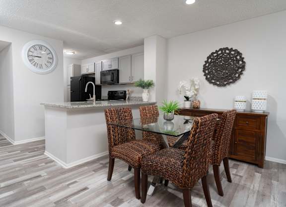 Renovated dining area at Britton Woods featuring granite counters, wood-style floors, and stainless steel appliances