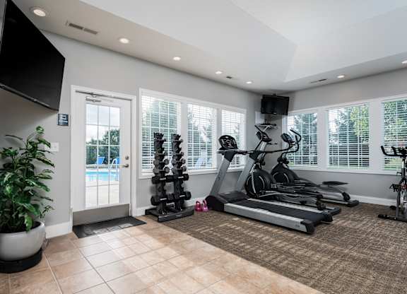The fitness center at Carson Farms in Delaware, OH, equipped with cardio machines, strength-training equipment, and bright natural lighting.