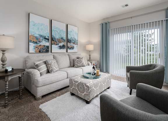 A living room with a grey couch, a coffee table, and a painting on the wall.