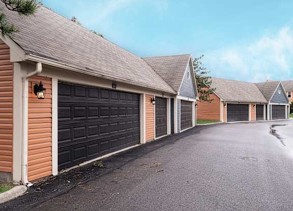 Exterior view of Fairway Lakes featuring black garage doors and a paved driveway.