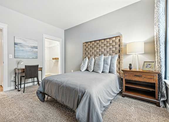 A bedroom with a large bed and a desk.