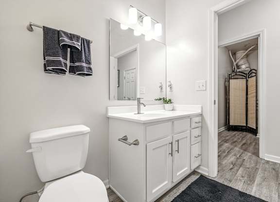 A white toilet sits next to a white sink in a bathroom.