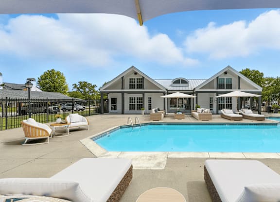 A large house with a pool in front.