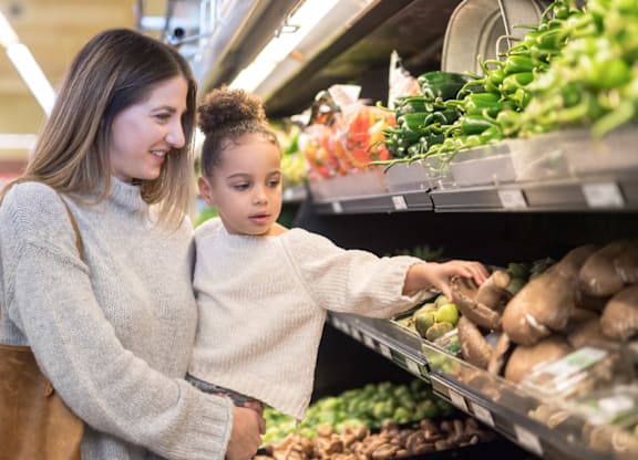 A woman and a child are shopping in a grocery store.