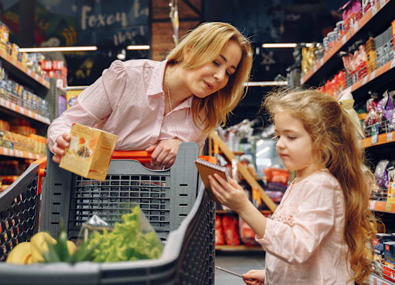 A woman and a girl are shopping in a grocery store.