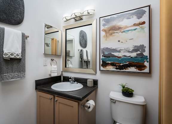 Compact bathroom with a sink and toilet, styled in neutral tones