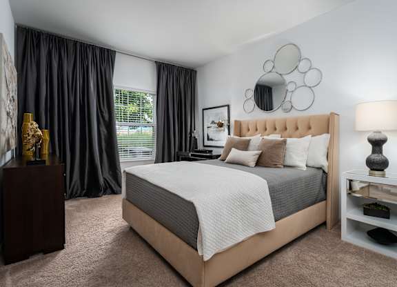 Cozy bedroom setup with bed, nightstand, and neutral tones at The Coleman Apartments