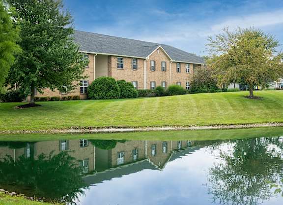 One-bedroom apartment building with landscaped grounds and pond views at The Coleman in Canal Winchester, OH