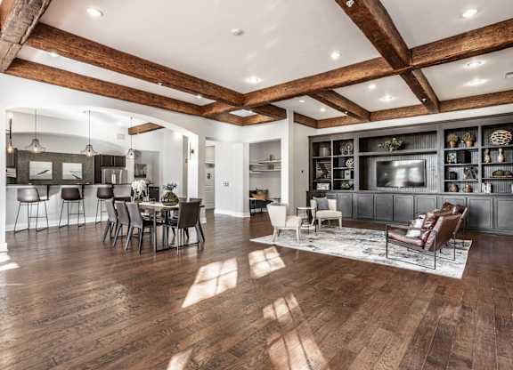 A spacious living room with wooden floors and a high ceiling.