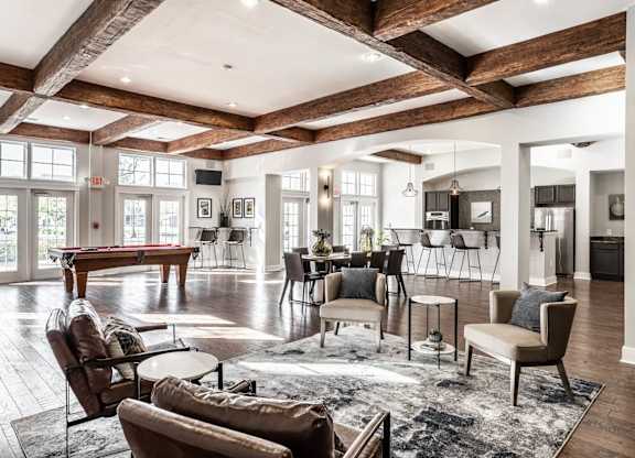 A spacious living room with wooden beams and furniture.