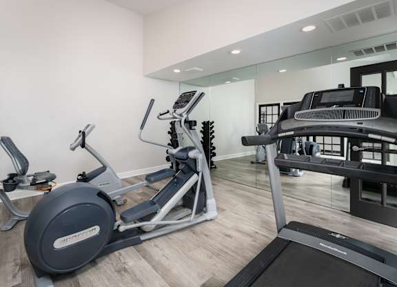 A fitness center in Reynoldsburg, OH with cardio equipment and weights on hardwood-style floors.