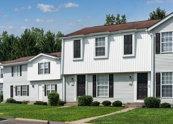 Exterior view of The Oaks with white panels and black shutters.