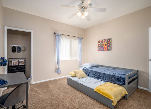 a bedroom with a bed and a ceiling fan