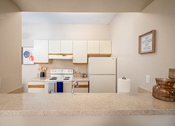 a kitchen with white cabinets and a white refrigerator