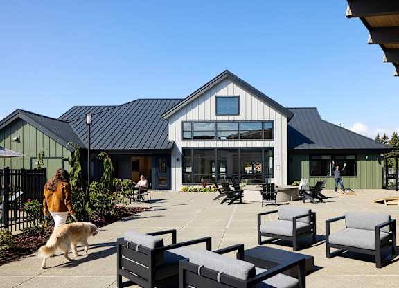 a dog walking on a patio in front of a building