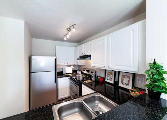 a kitchen with white cabinets and stainless steel appliances
