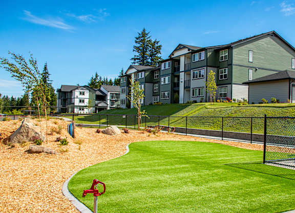 A red flag marks the corner of a well-kept lawn in front of apartment buildings.