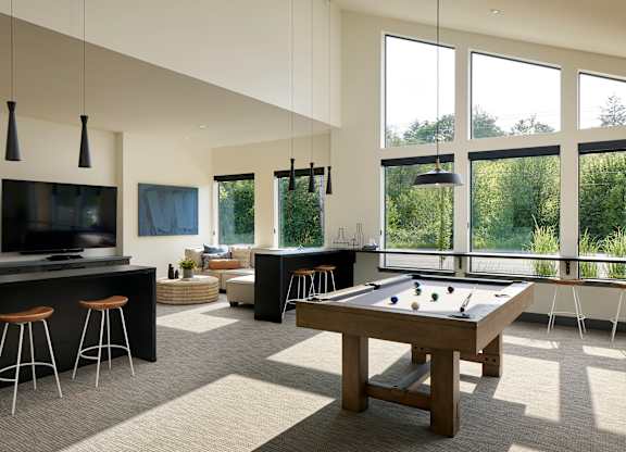 an open living room with a pool table and a flat screen tv