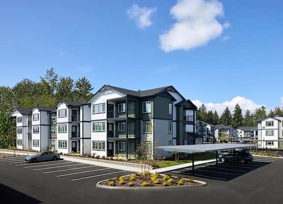 a rendering of a large apartment building with a parking lot in front of it