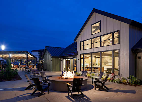 a fire pit sits in front of a building with large windows