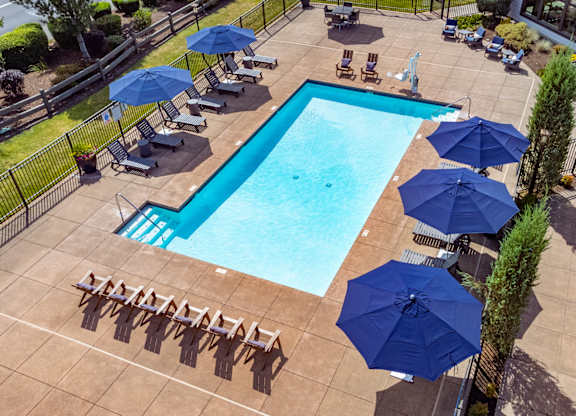 a swimming pool with umbrellas and chairs around it