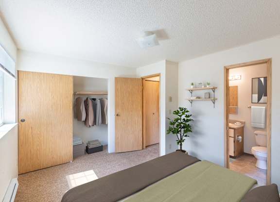 A room with a bed, a toilet, and a plant.