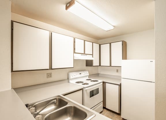 a kitchen with white cabinets and white appliances