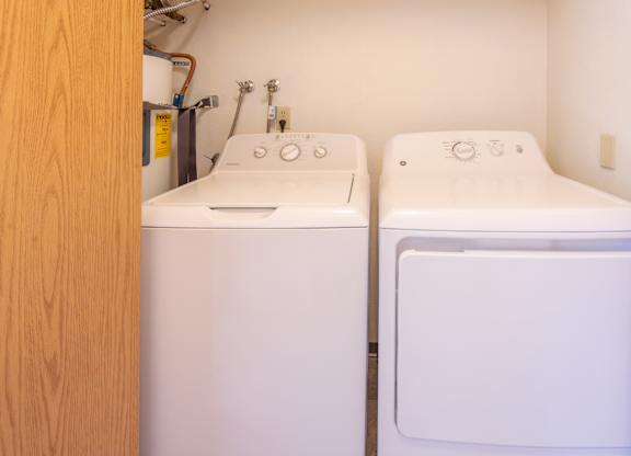 A white washing machine and dryer in a small laundry room.