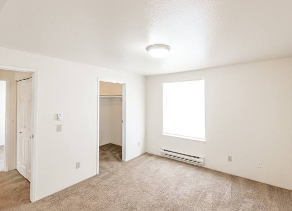 a bedroom with white walls and carpet