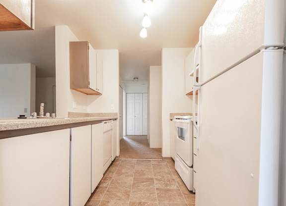 a kitchen with white cabinets and white appliances