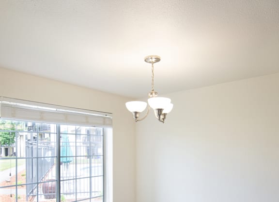an empty room with a large window and a chandelier