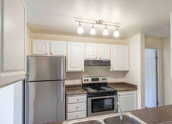 a kitchen with white cabinets and stainless steel appliances