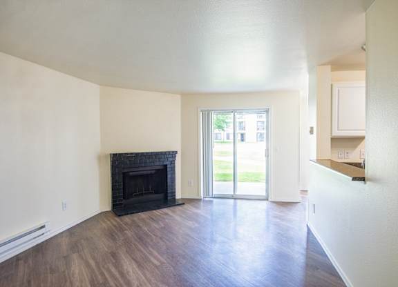 a living room with a fireplace and a doorway into a kitchen