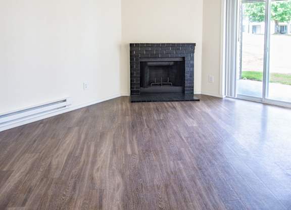 a living room with hardwood floors and a fireplace