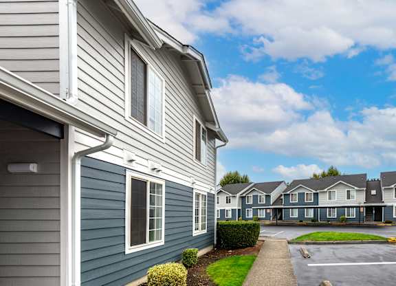 a row of houses with blue siding and a parking lot
