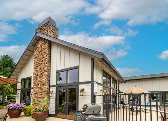 the exterior of a building with a patio and a grill