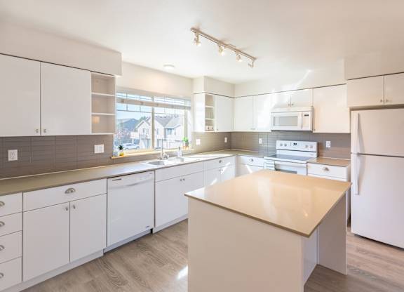 a kitchen with white cabinets and white appliances