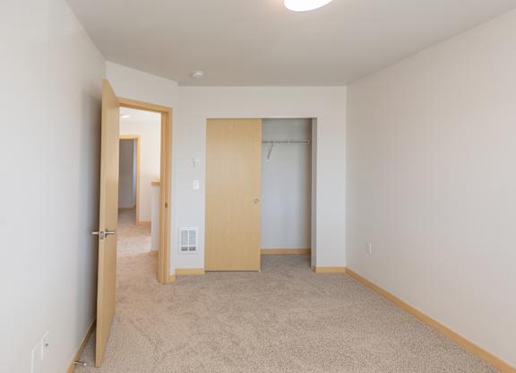a bedroom with white walls and carpet