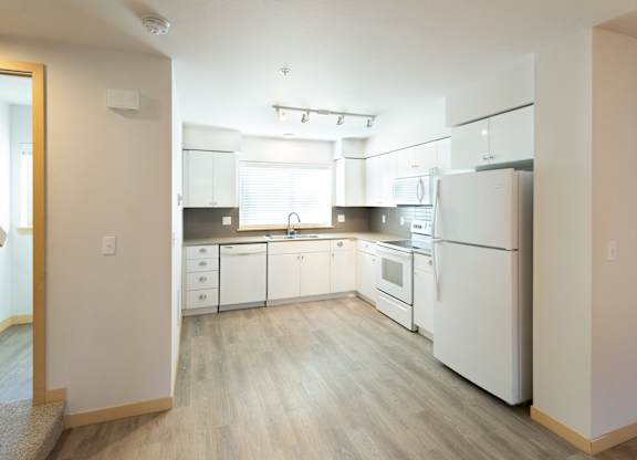 a kitchen with white appliances and white cabinets
