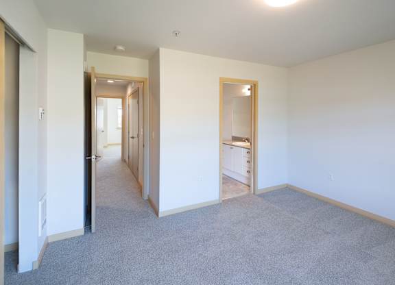 a bedroom with white walls and carpet