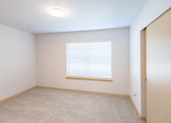 a bedroom with a large window and a wooden door