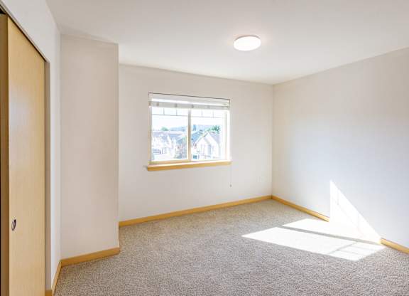 an empty room with a window and a door
