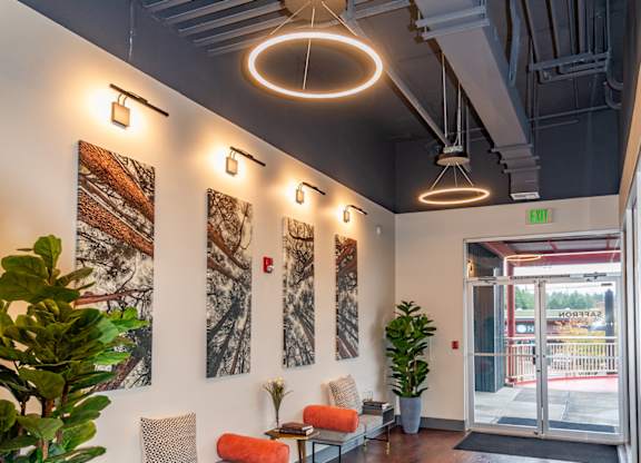 a lobby with chairs and plants and a glass door