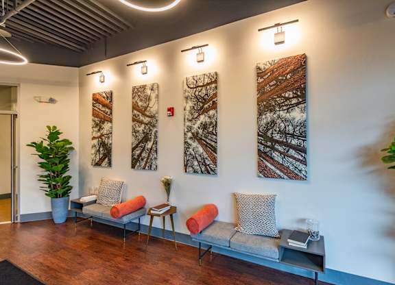 a living room with couches and paintings on the wall