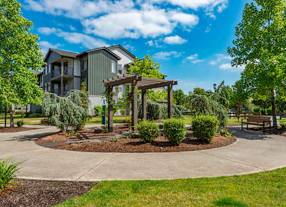 a park with a pavilion and benches in front of a building