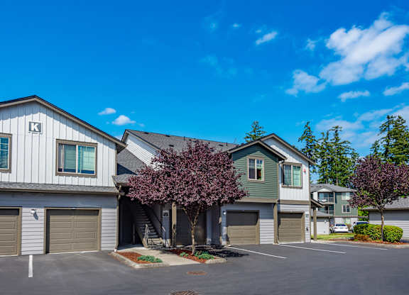 a house with two garages and a tree in front of it