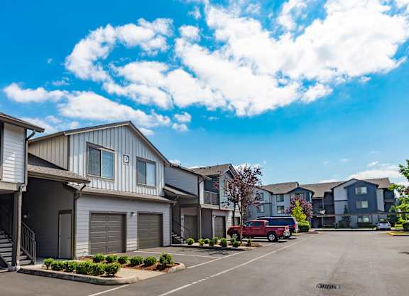 a row of houses with a red truck parked in a parking lot