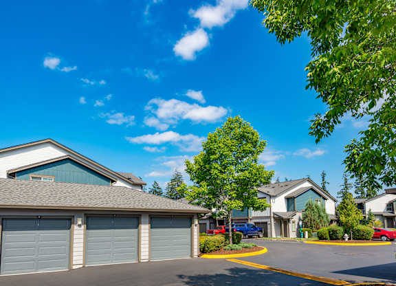 a neighborhood of garages with cars parked in front of them