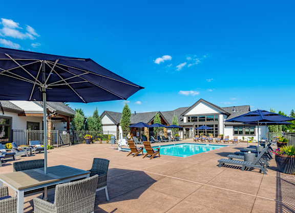 our apartments have a pool and patio with chairs and umbrellas